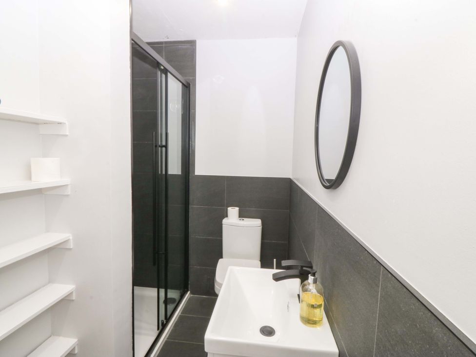 A bathroom with a shower, sink, and toilet at Nyth Y Fran in Abersoch