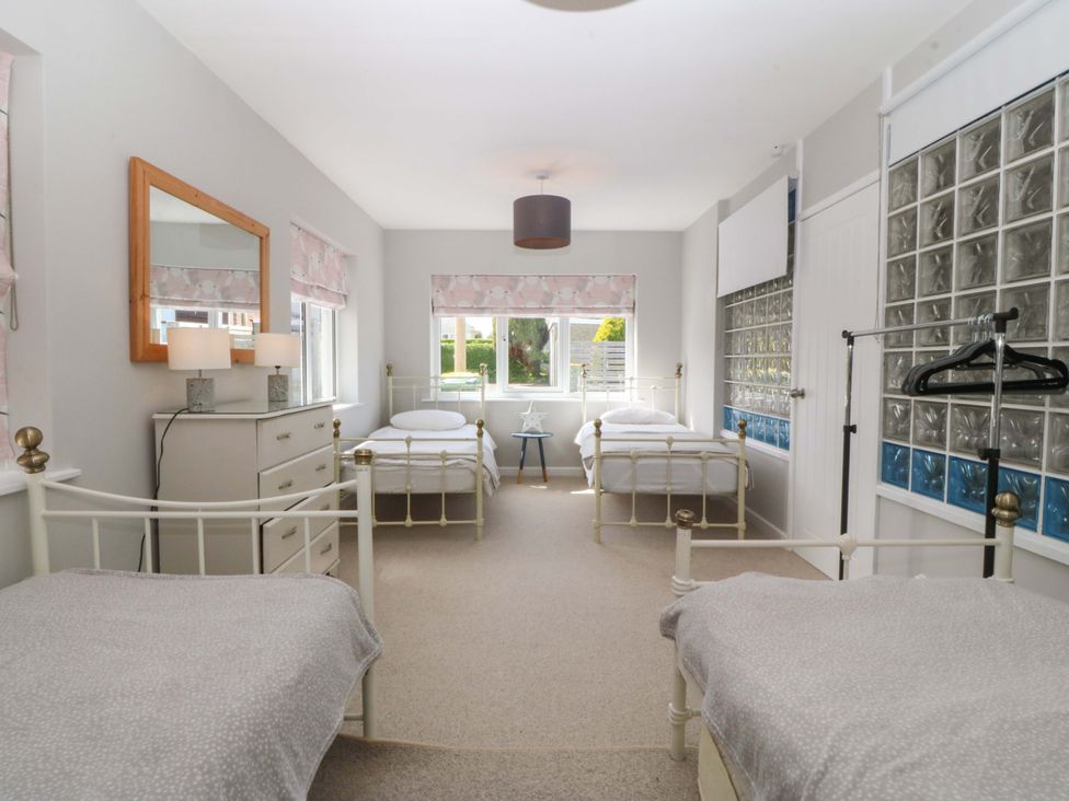 A bedroom with two beds and a dresser at Nyth Y Fran in Abersoch