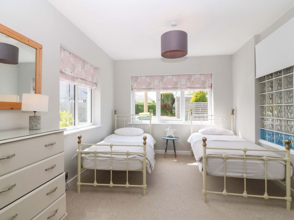 A bedroom with two beds and a dresser at Nyth Y Fran in Abersoch