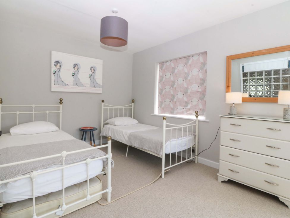 A bedroom with two single beds and a dresser at Nyth Y Fran in Abersoch