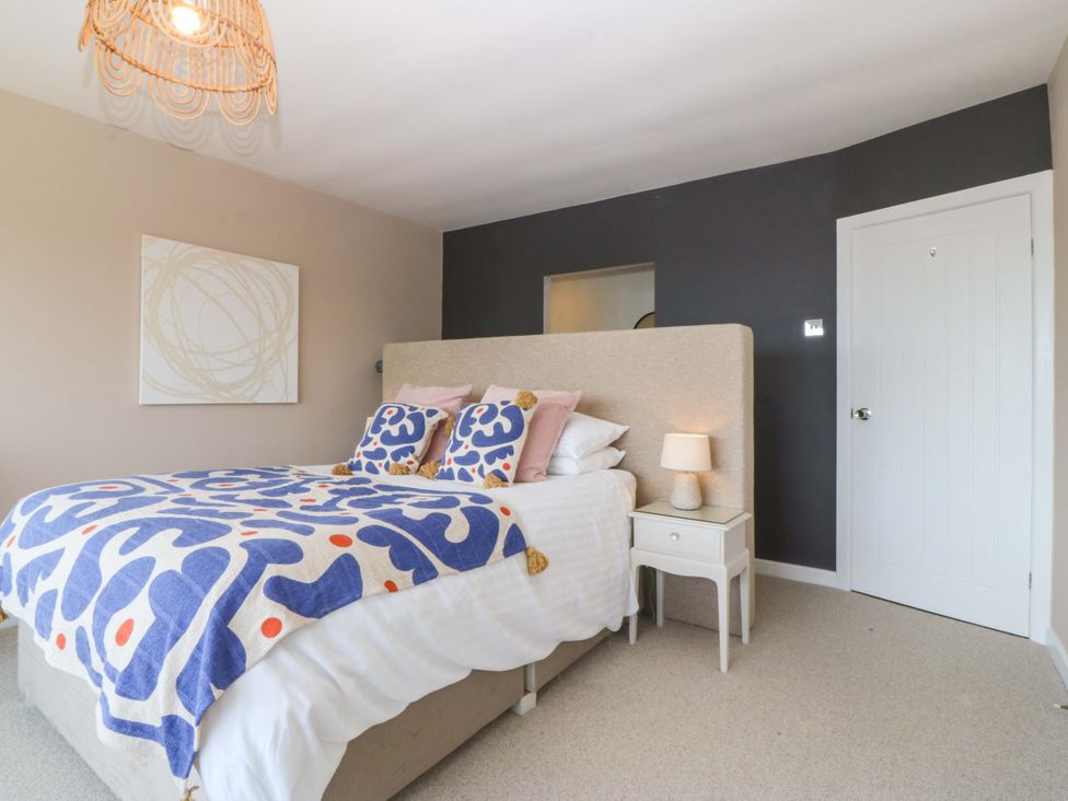 A bedroom with a bed and nightstand at Nyth Y Fran Abersoch