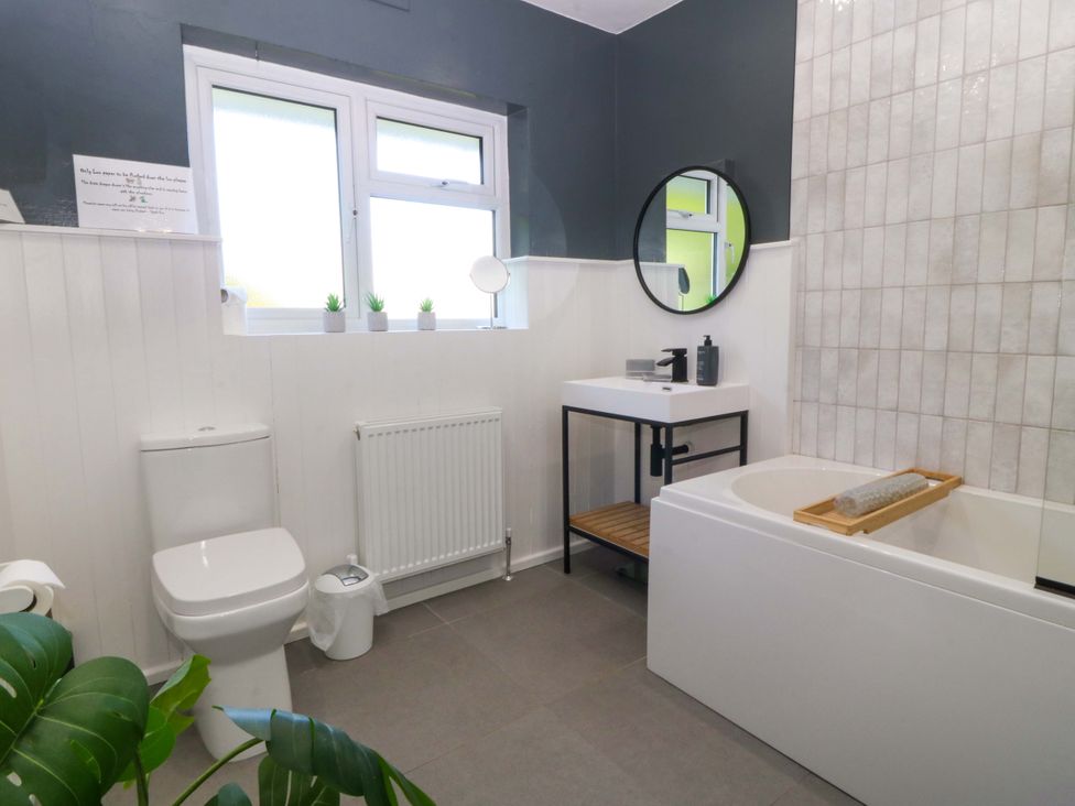 A bathroom with a sink, toilet, and bathtub at Nyth Y Fran in Abersoch