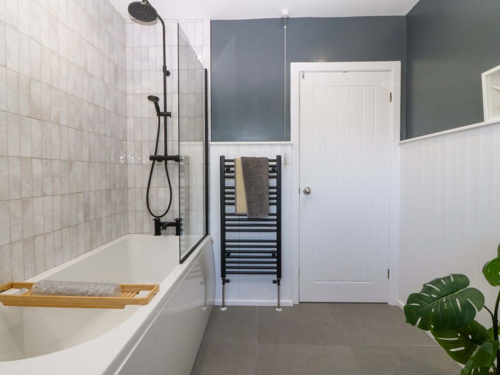 A bathroom with a bathtub and shower at Nyth Y Fran in Abersoch