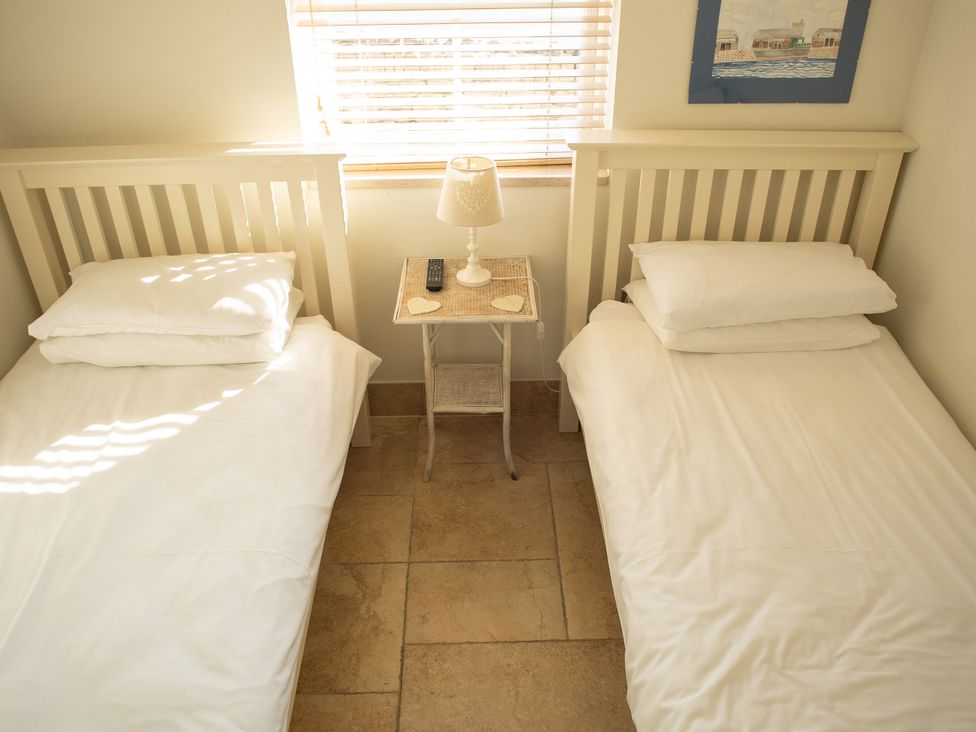 A bedroom with two single beds and a bedside table at Pen Y Sarn near Abersoch