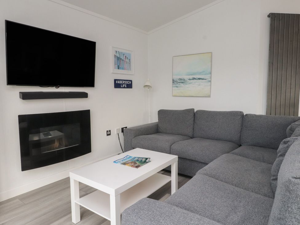 A living room with a sofa and television at The Warren D7 in Abersoch