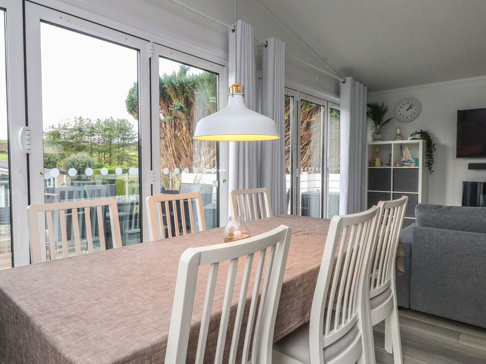 A dining room with a table and chairs at The Warren D7 Abersoch