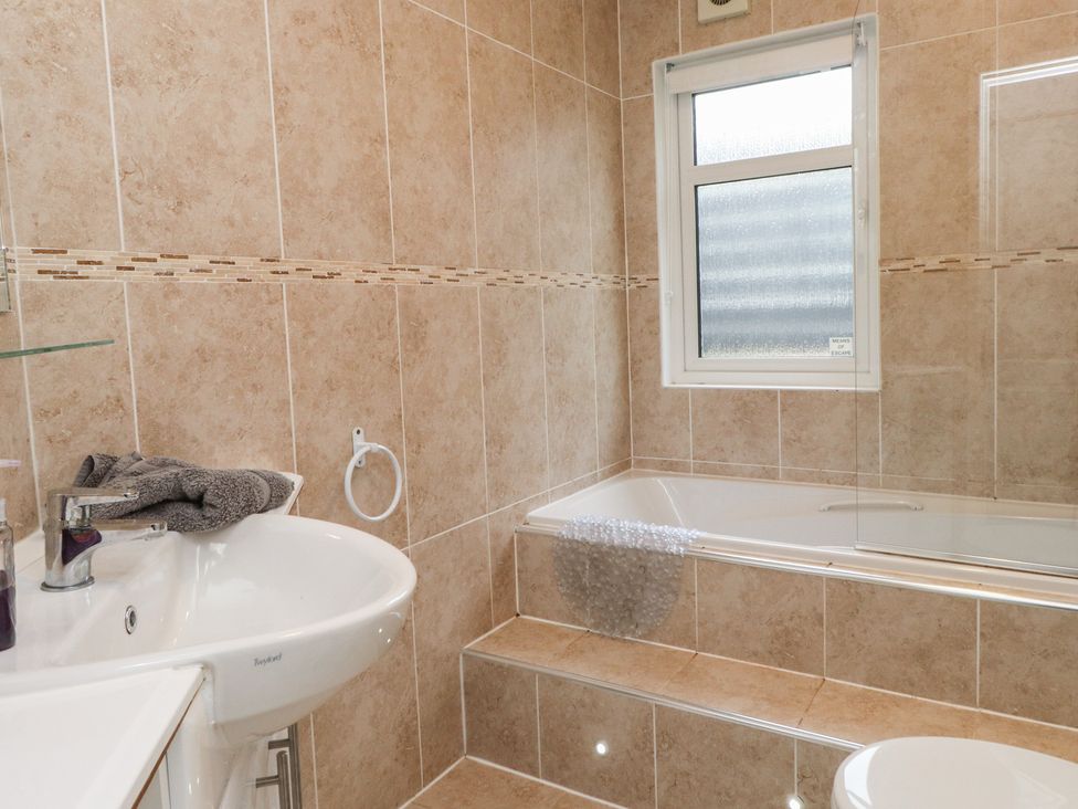 A bathroom with a bath and sink at The Warren D7 in Abersoch