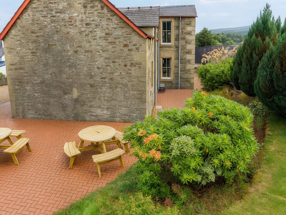 An outdoor area with a patio, table, and plants at Tayview in Killin