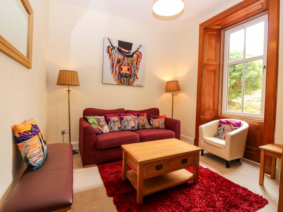 A living room with a sofa and armchair at Tayview in Killin