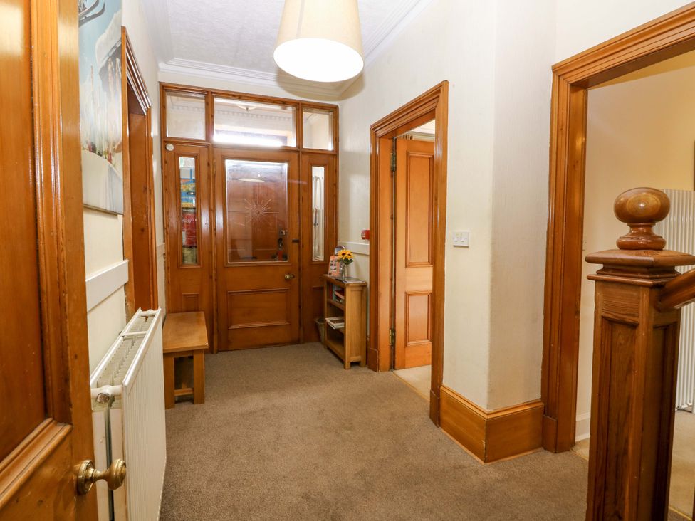 A hallway with a door and bench at Tayview in Killin