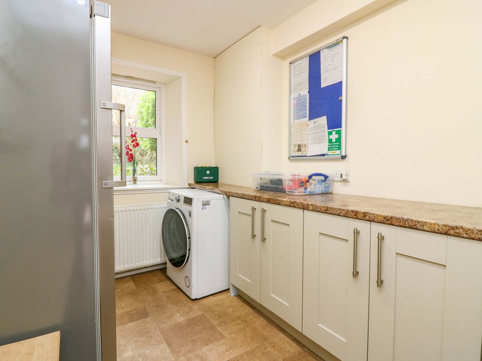 A laundry room with a washing machine and cabinets at Tayview in Killin