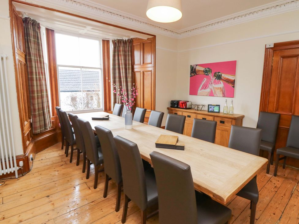A dining room with a long wooden table and chairs at Tayview in Killin
