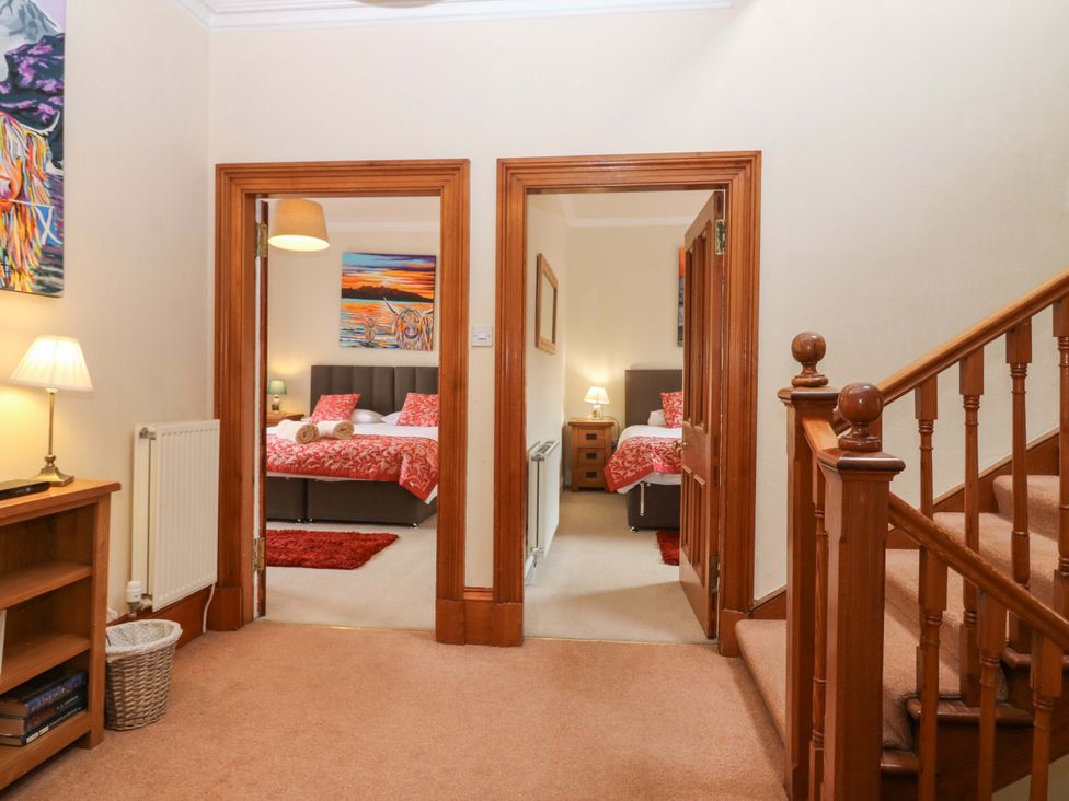 A hallway with doors to two bedrooms and a staircase at Tayview in Killin