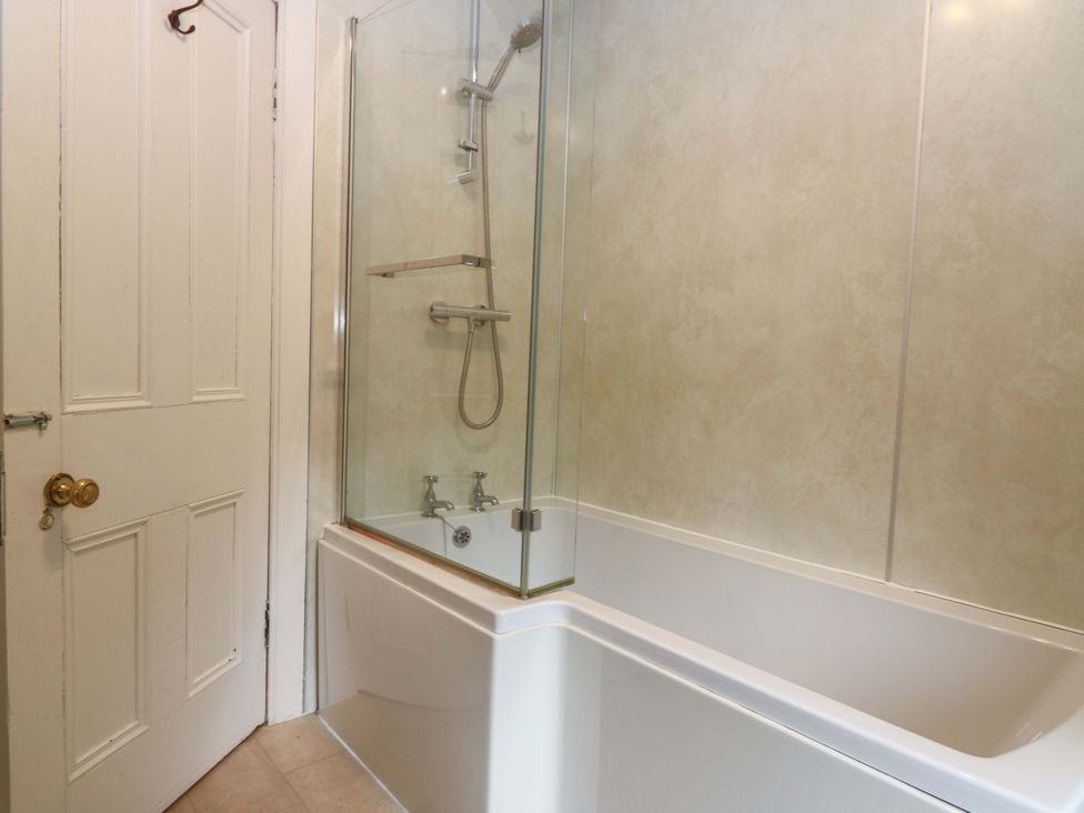 A bathroom with a shower over a bathtub at Tayview in Killin
