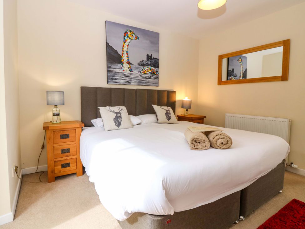 A bedroom with a bed and nightstands at Tayview in Killin