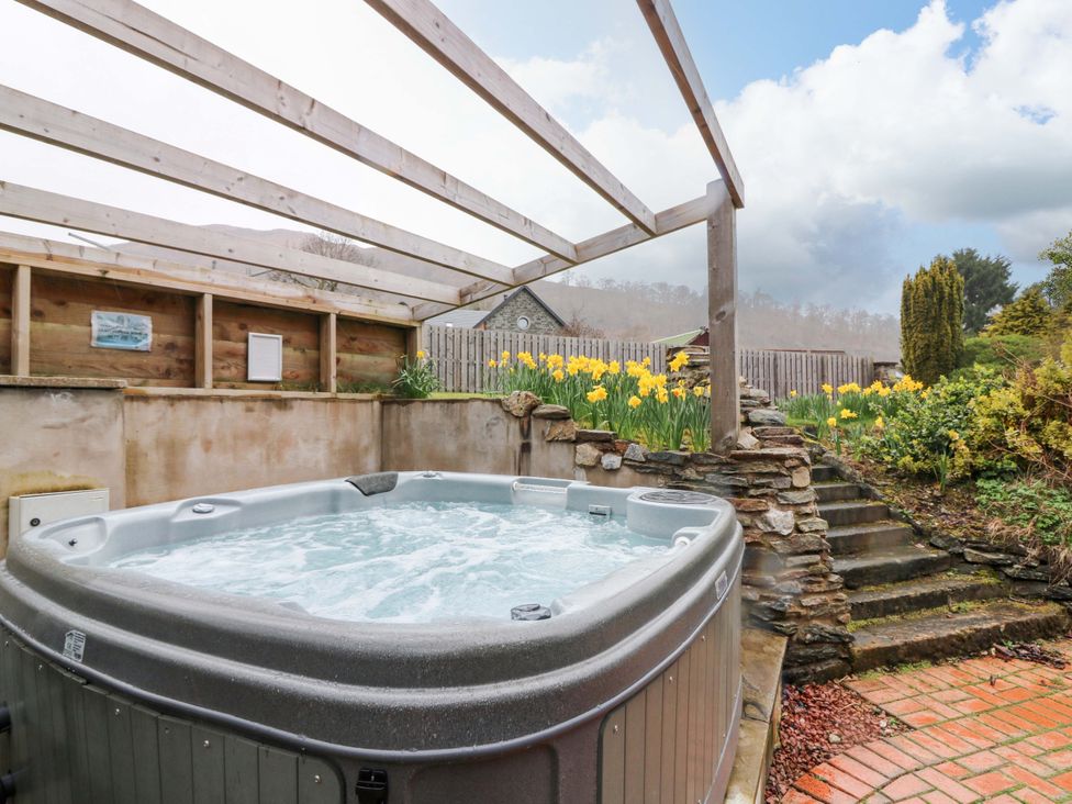 A hot tub surrounded by flowers and steps at Tayview in Killin