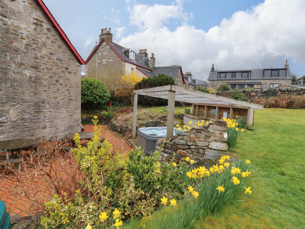 A garden with a hot tub and flowers at Tayview in Killin
