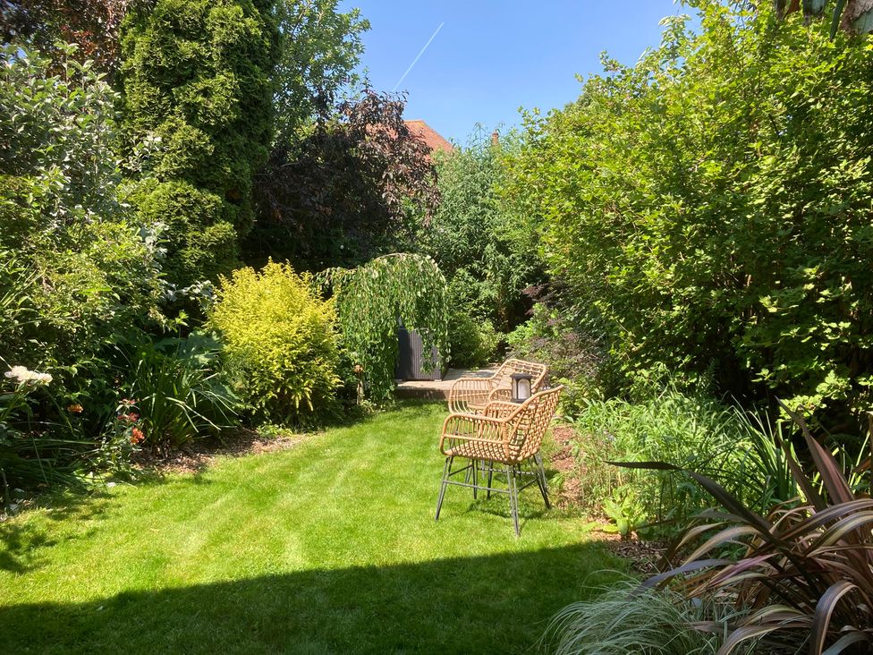 A garden with chairs and plants at Gingerbread Cottage in Canterbury