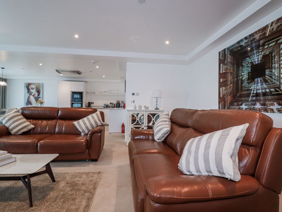 A living room with leather sofas and a coffee table at 13 Cliff Edge in Newquay