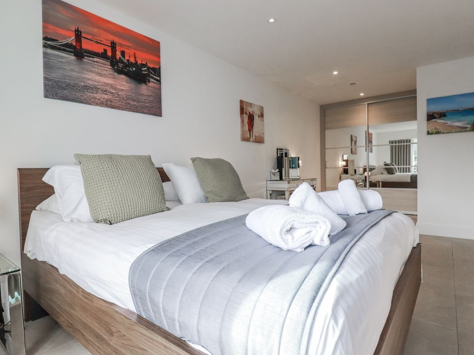 A bedroom with a bed and mirrored wardrobe at 13 Cliff Edge Newquay