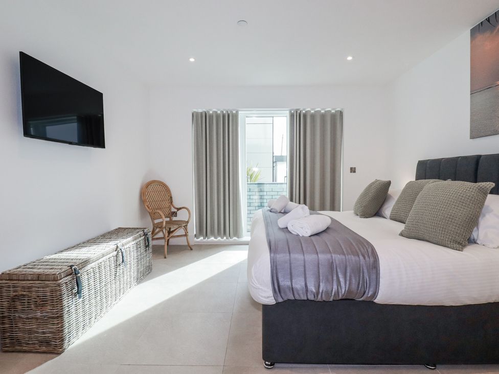 A bedroom with a bed and television at 13 Cliff Edge in Newquay