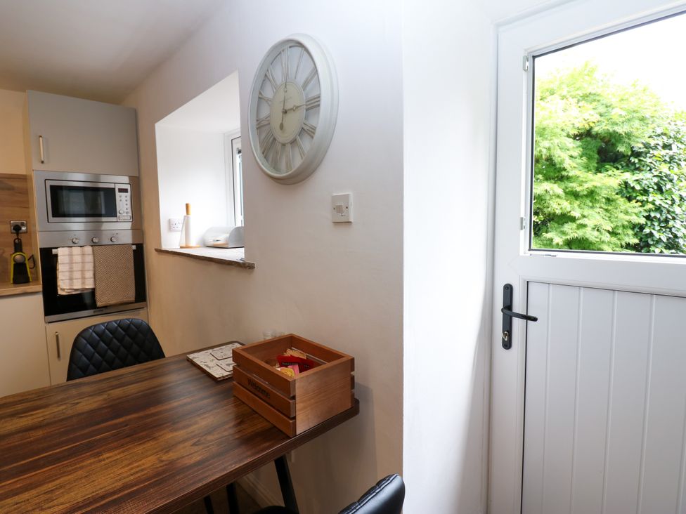A kitchen with a table and appliances at La'l Skaithe in Soulby near Kirkby Stephen