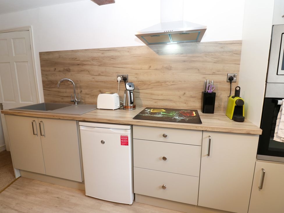 A kitchen with a sink, toaster, kettle, and fridge at La'l Skaithe Soulby near Kirkby Stephen