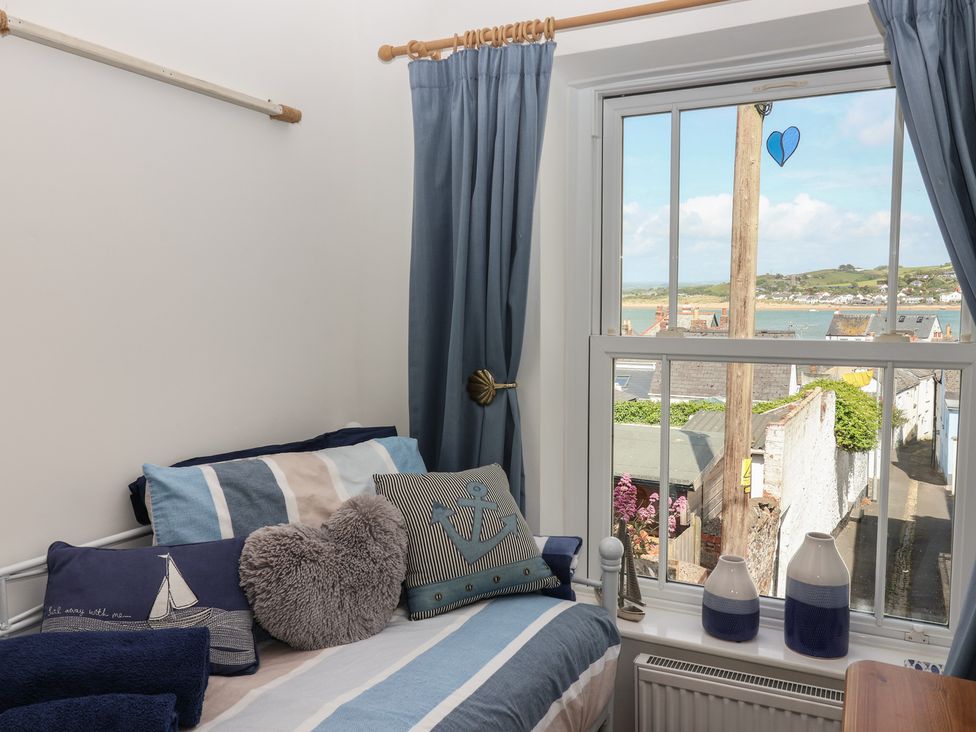 A bedroom with a window view at Honeymoon Cottage in Appledore