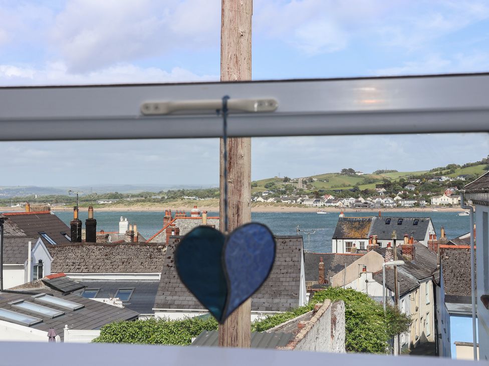 A view from a window showing houses and ocean at Honeymoon Cottage in Appledore