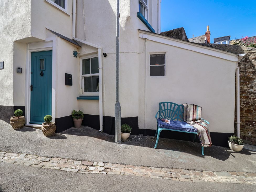 An outdoor area with a blue door and a bench at Honeymoon Cottage Appledore