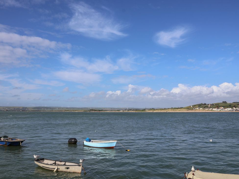 A view of boats on water under a cloudy sky at Honeymoon Cottage in Appledore