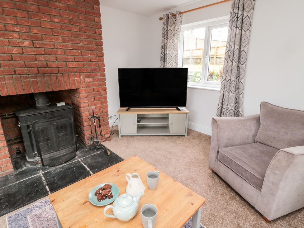 A living room with a fireplace and television at Whinney Moor