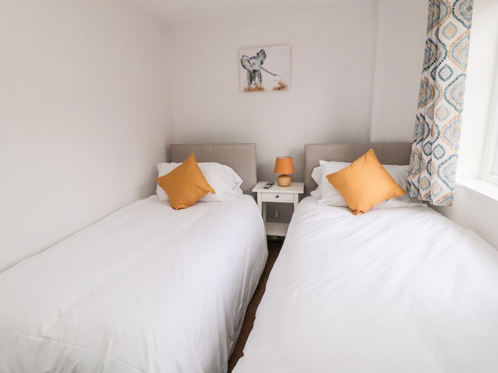 A bedroom with two single beds and a bedside table at Whinney Moor