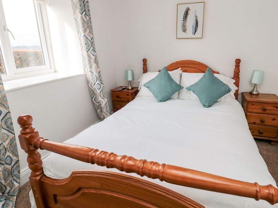 A bedroom with a bed and nightstand at Whinney Moor