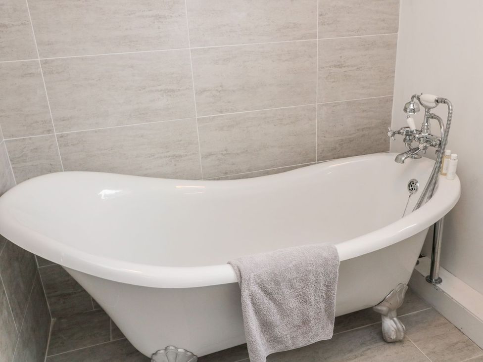 A bathtub with a towel hanging on it at Whinney Moor