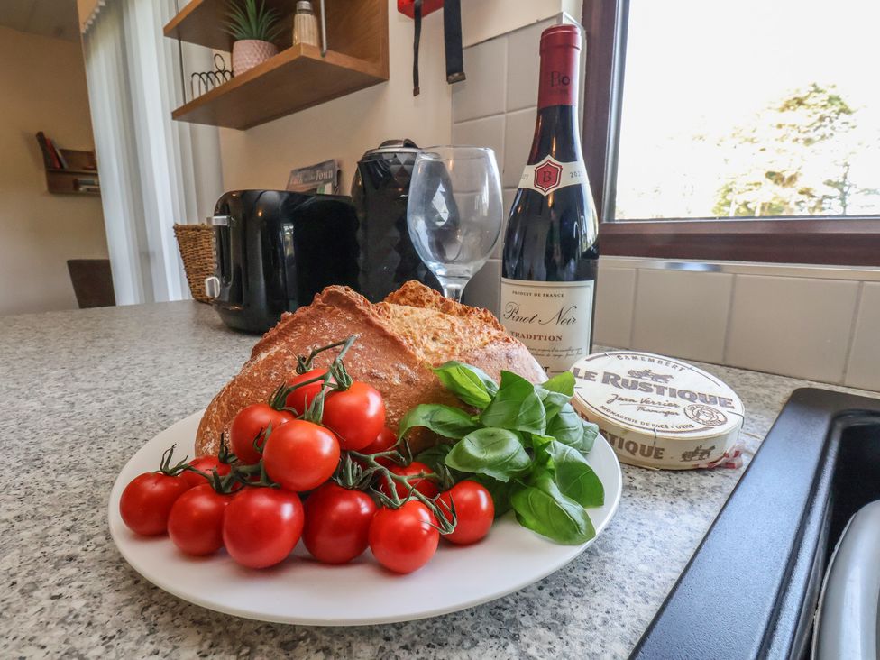 A kitchen with tomatoes, bread, basil, wine and cheese at Bugle, Saltburn-By-The-Sea