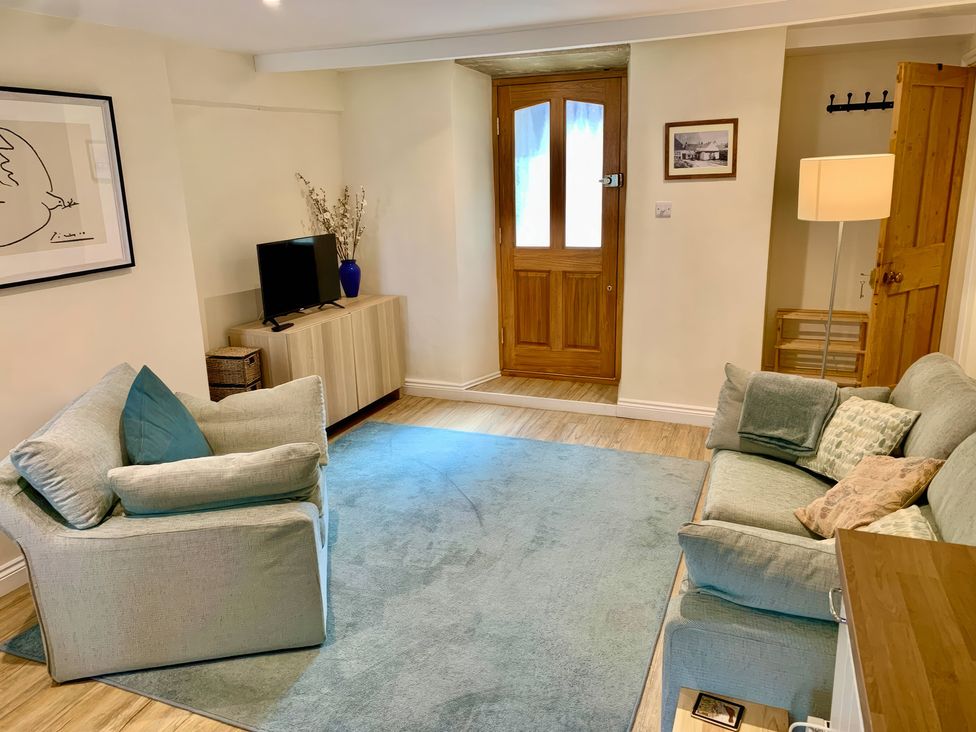 A living room with a sofa and television at Bobbin Cottage in Swanage