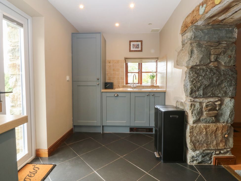 A kitchen featuring a sink and cabinets at Beudy Penarddwnion Rhydymain near Dolgellau