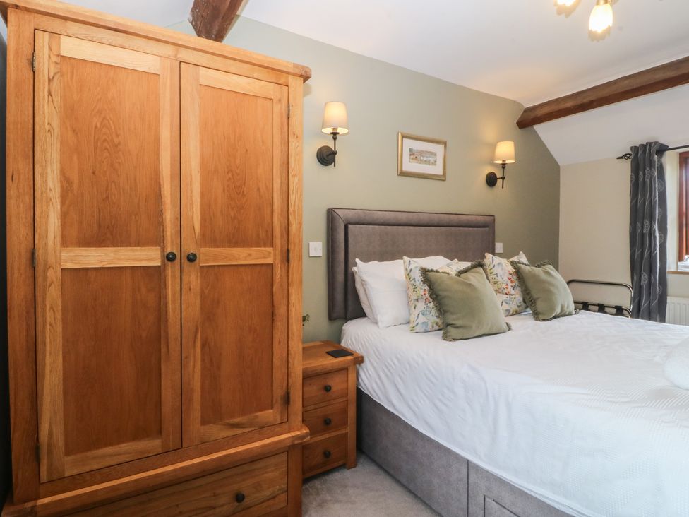 A bedroom with a bed and wardrobe at Beudy Penarddwnion near Rhydymain