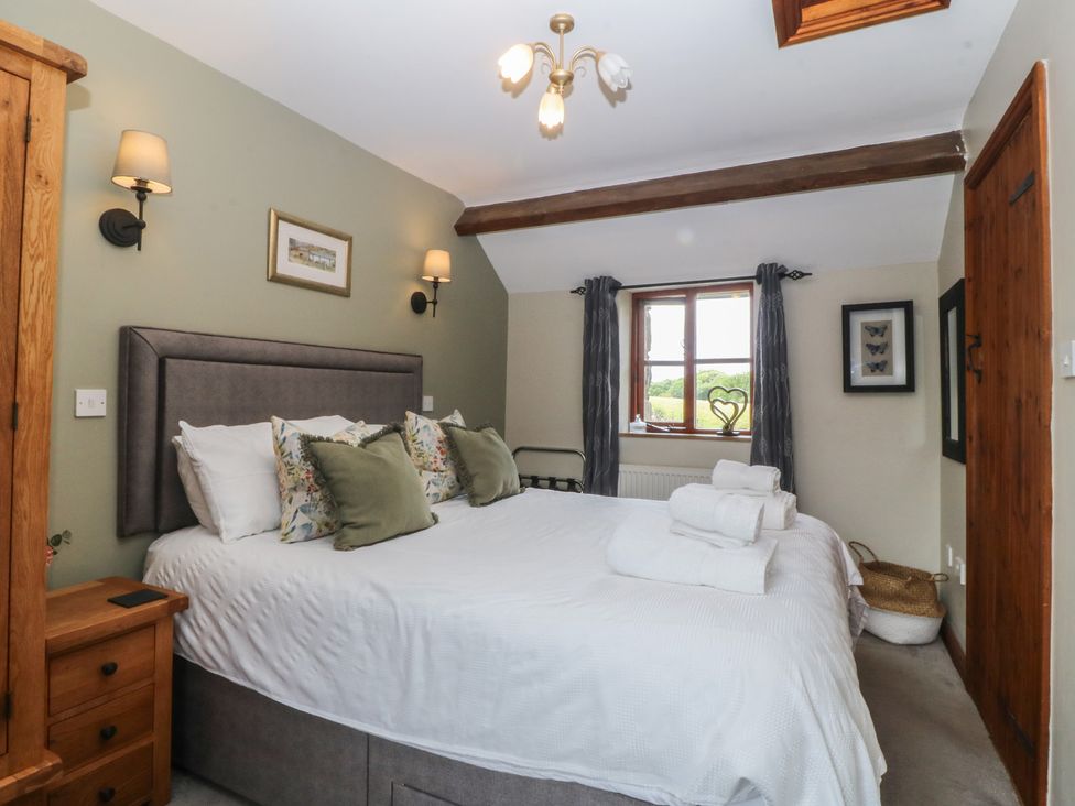 A bedroom with a bed and wardrobe at Beudy Penarddwnion near Rhydymain