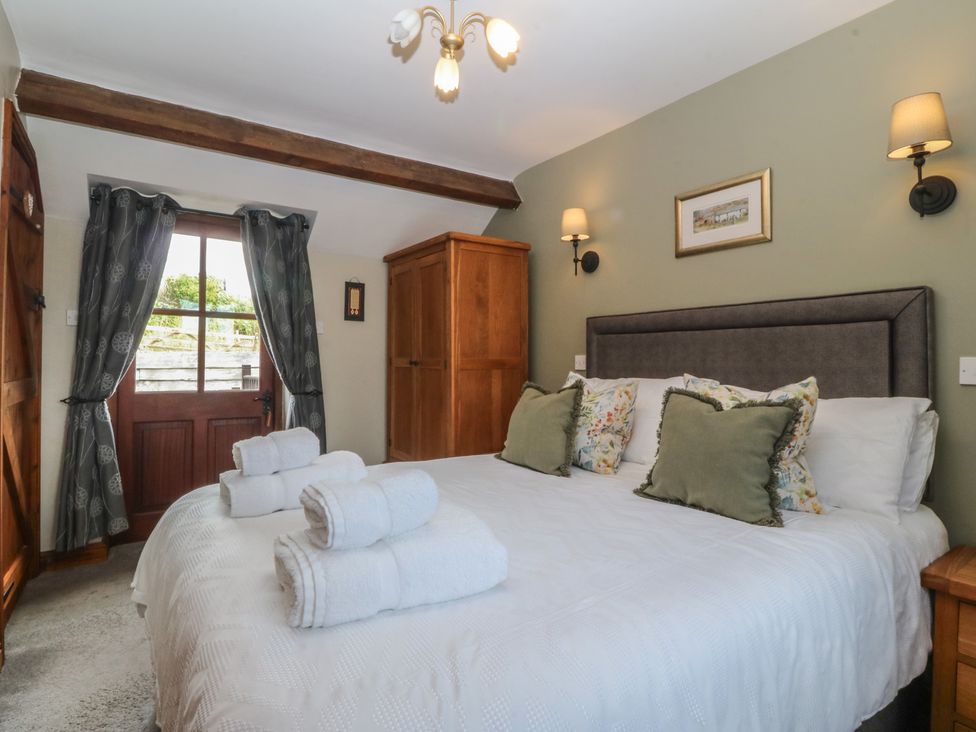A bedroom with a double bed and wardrobe at Beudy Penarddwnion Rhydymain near Dolgellau