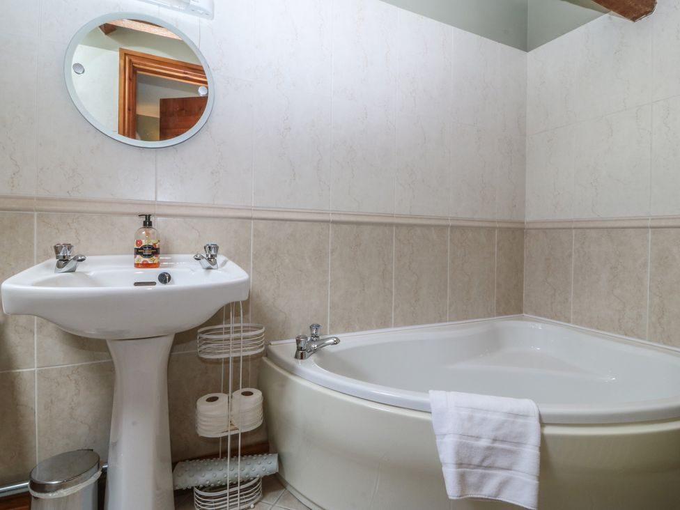 A bathroom with a bath tub and sink at Beudy Penarddwnion near Rhydymain