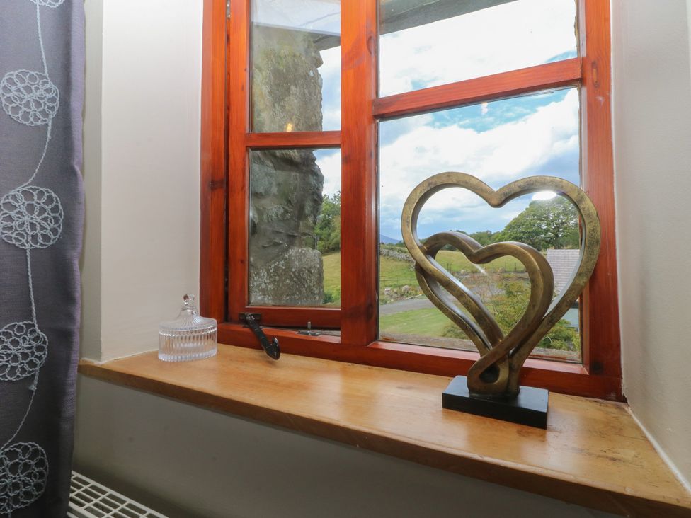 A window with a heart sculpture on the sill at Beudy Penarddwnion Rhydymain near Dolgellau