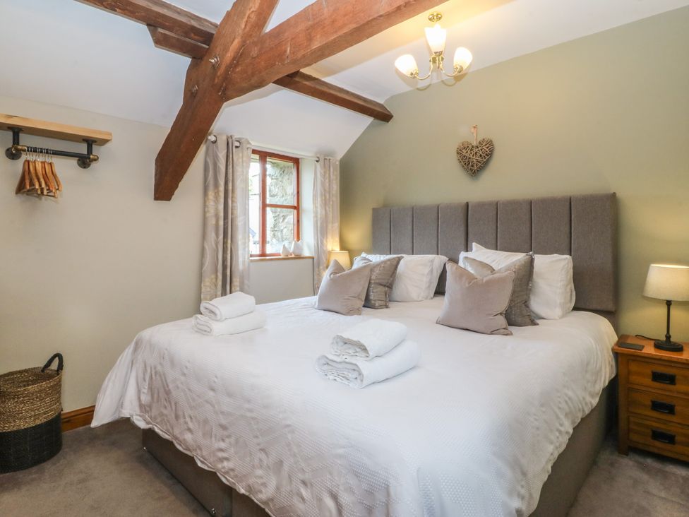 A bedroom with a bed and window at Beudy Penarddwnion Rhydymain near Dolgellau