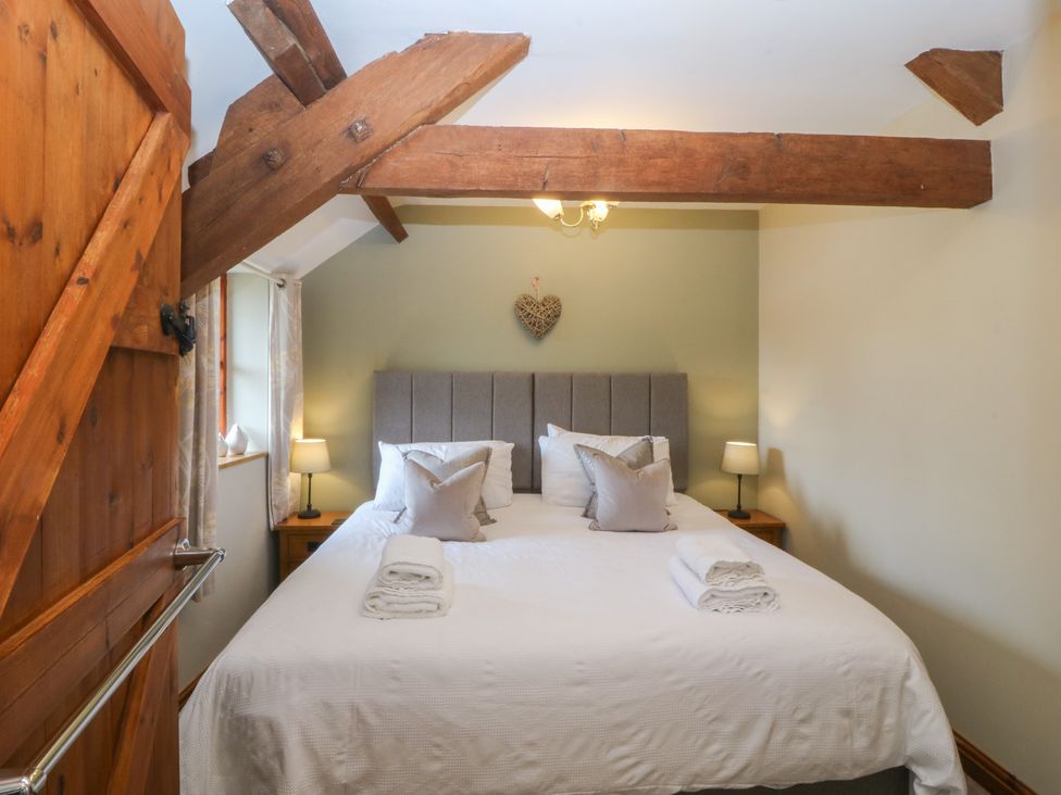 A bedroom with a double bed and bedside lamps at Beudy Penarddwnion Rhydymain near Dolgellau