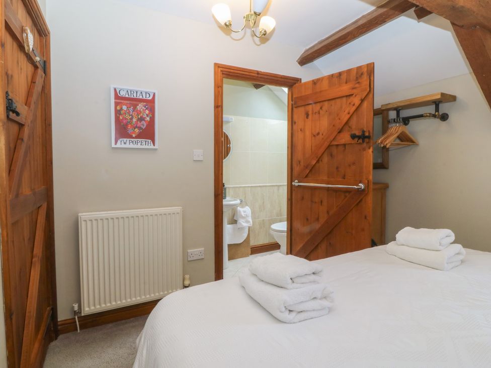 A bedroom with a bed and towels at Beudy Penarddwnion in Rhydymain near Dolgellau