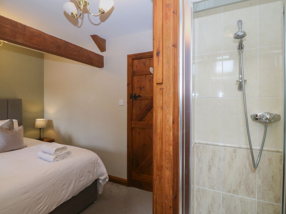 A bedroom with a bed and a shower at Beudy Penarddwnion Rhydymain near Dolgellau