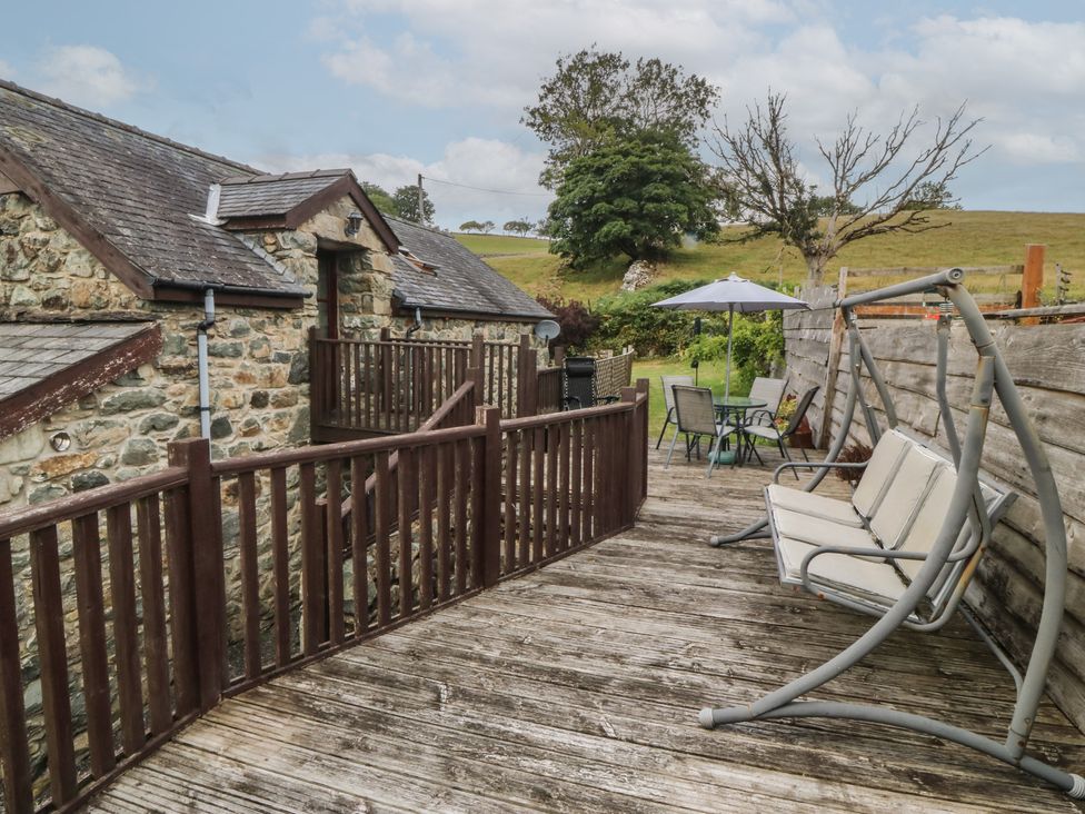An outdoor area with a swing seat and table at Beudy Penarddwnion Rhydymain near Dolgellau