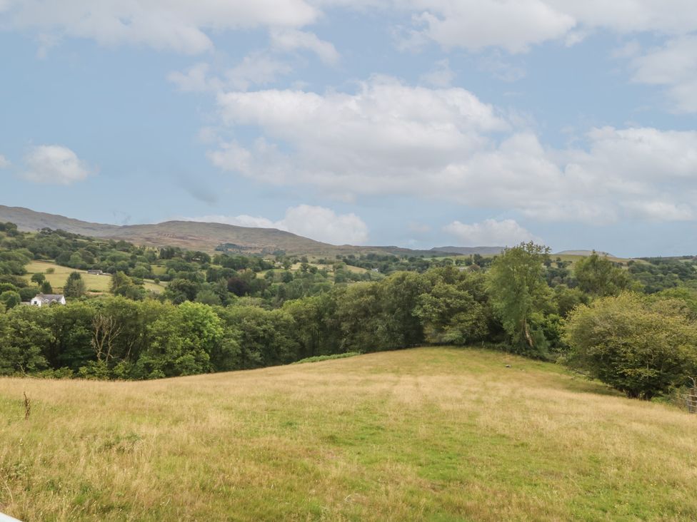 A landscape view of a field and mountains at Beudy Penarddwnion in Rhydymain near Dolgellau