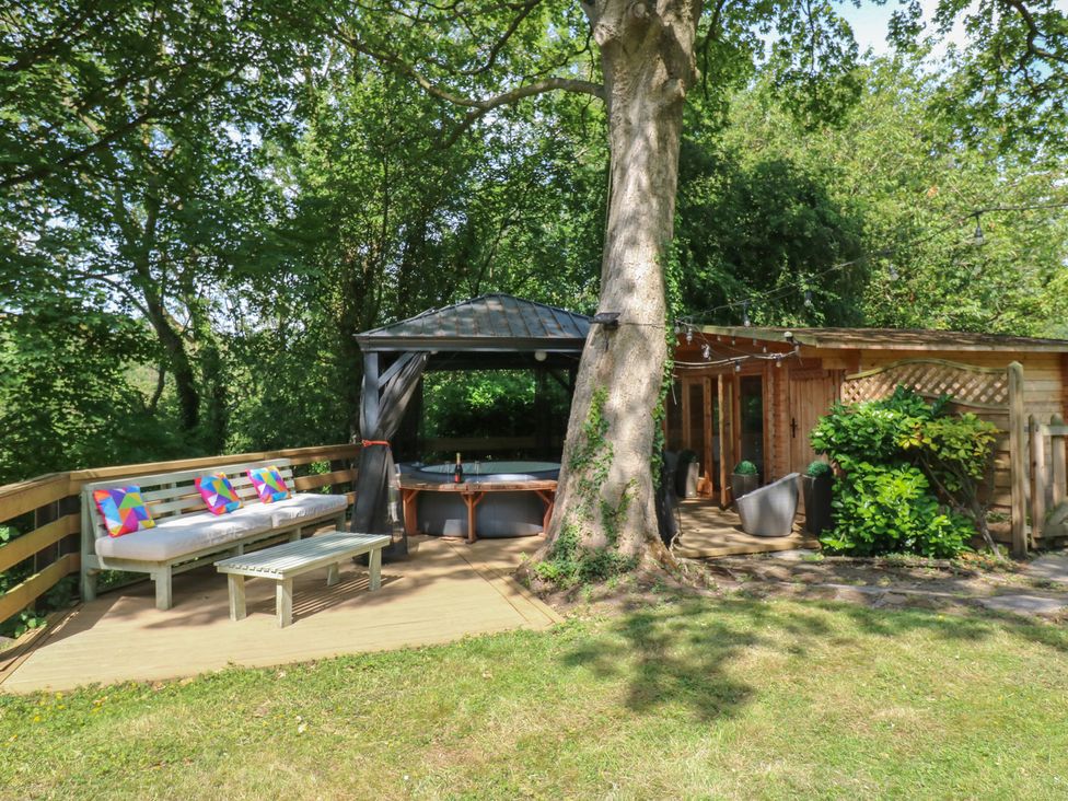 An outdoor area with a gazebo, hot tub, couch, and coffee table at Glebe House in Dalton-le-Dale near Murton, County Durham